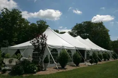 Zelt mit spitzen D&auml;chern, umgeben von B&auml;umen und Str&auml;uchern, bei sonnigem Wetter. Climate Energy.