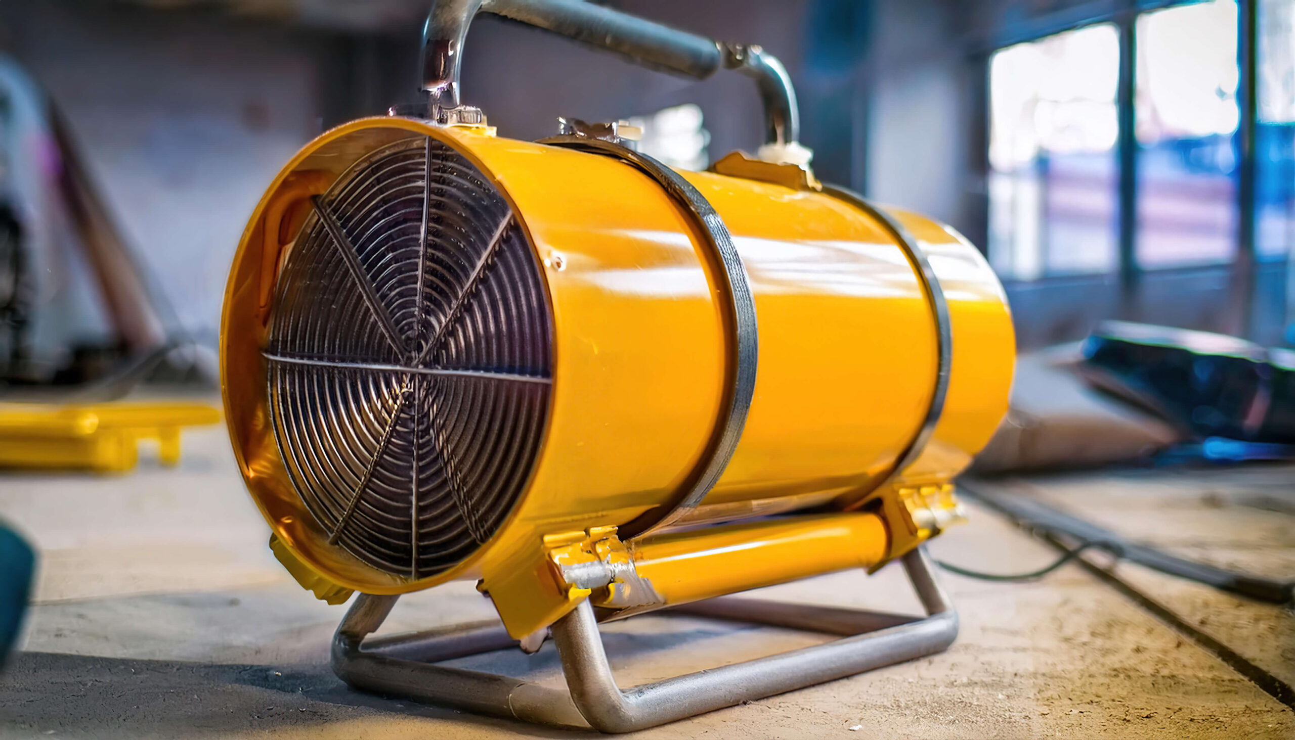 Gelber elektrischer Bauheizer in Industrieumgebung &ndash; effiziente mobile W&auml;rme.